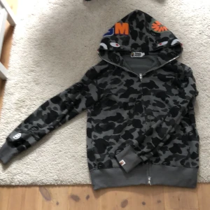 Bape hoodie - En svart och grå bape hoodie som är sparsamt använd. Köptes för några månader sedan. Väldigt fräsch.  Priset är inte hugget i sten så kom gärna och förhandla✔️ Dm för mer information och bilder😁 kan även bytas😎