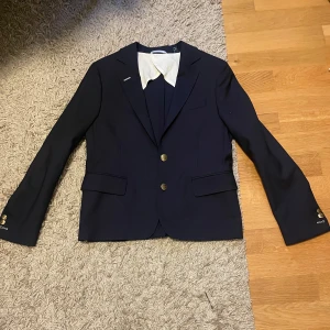 Gant kavaj - Marinblå Gant kavaj i storlek xs, använd endast två gånger därför är den i väldigt bra skick. Extra knappar medföljer.