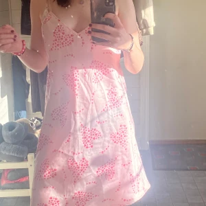 Rosa klänning - Rosa söt klänning med hjärtan på. Materialet är likt siden. 