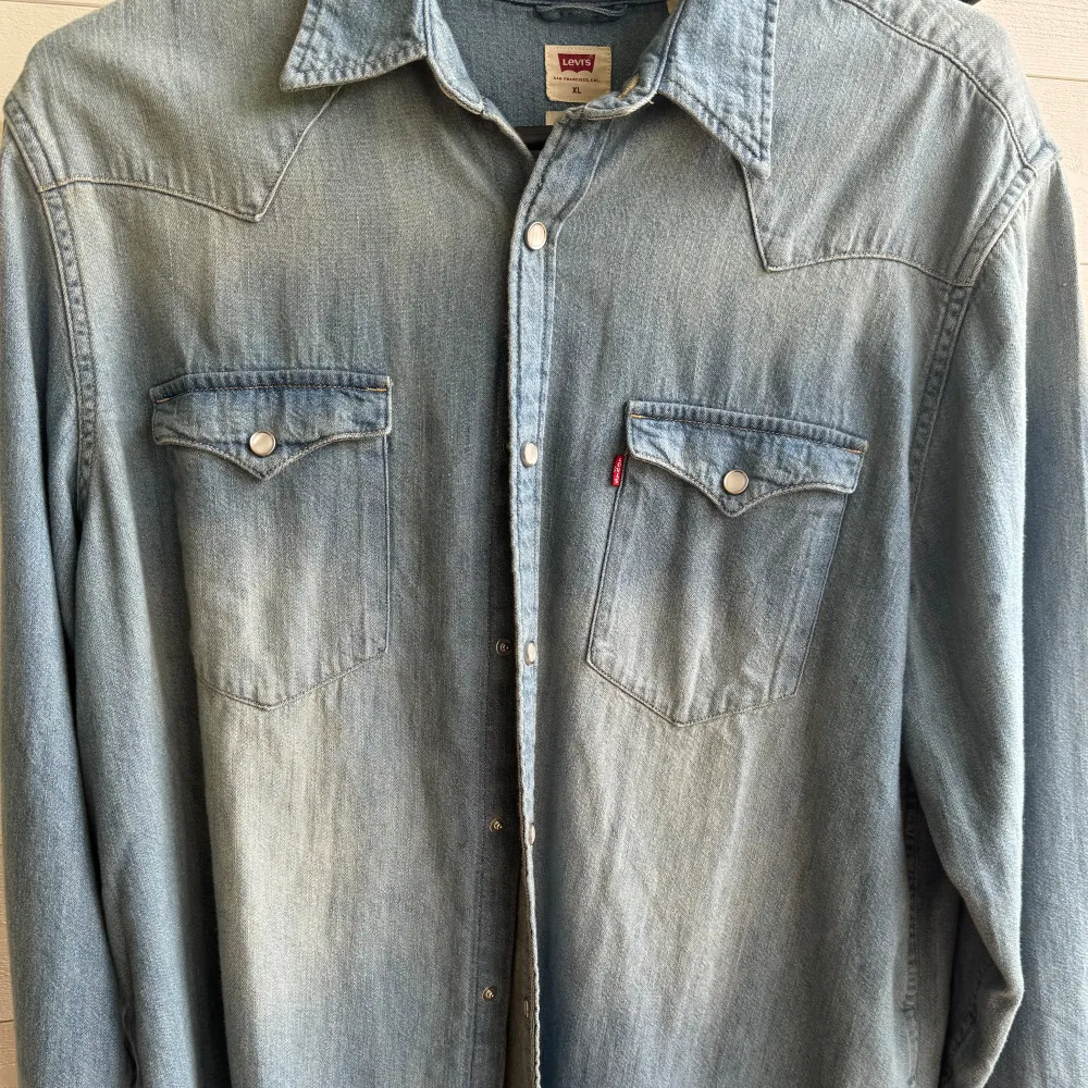 Säljer denna oanvända jeansskjorta från Levi's (inte min skjorta). Endast testad. Nypris 495 kr.. Skjortor.