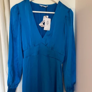 Blå midiklänning,  - Miniklänning från stradivarius, i satin. Långärmad, slits i fram på sidan. Helt ny. Lapparna kvar