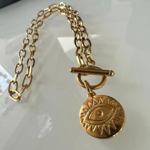 Halsband  - perfekt för dig som letar efter ett vackert halsband som komplettera din outfit. Halsbandet har en längd på cirka 40cm vilket gör att det passar bekvämt runt din hals. Berlocken på denna är utformat som ett öga 👁️ 