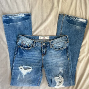 Lågmidjade Bootcut jeans hollister  - Lågmidjade jeans från hollister, enligt lapp storlek 26 men sitter enligt mig mer som en 27. Innerbenslängd: 72 midjemått: 37 vill du köpa trycker du på köp nu, jag postar 24h