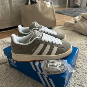Helt nya gråa adidas campus 00s  - Aldrig använda, nyskick  Storlek 38 Får även med extra gråa snören 