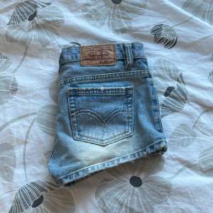 Jättefina jeansshorts från Levi’s💕 Köpt av en tjej på plick men var försmå. Midjemåttet är 38 cm (rakt över). Endast testade. Har ett litet hål vid en av bälteshällorna men är i jättebra skick! De första 3 bilderna är lånade av förra ägaren💗