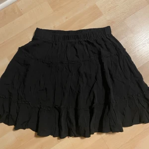 Svart fladdrig kjol - Svart kort kjol med volanger, passar xs-m beroende på hur du vill den ska sitta 