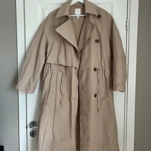 Beige trenchcoat - En dov fläck som jag precis upptäckte vid ena fickan så inget jag nånsin tänkt på, annars i väldigt fint skick! 