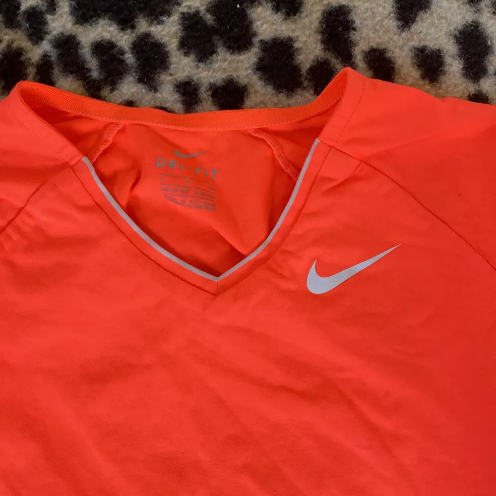 Så fin lys orange tröja från Nike❤️är i storlek 8-10 men är elastisk❤️. T-shirts.