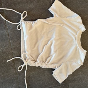 T-Shirt med knyt - Jag säljer min t-shirt🥰 Den har knyt med snöre på sidorna, inte kommit till användning för min del. Så inga skador eller fläckar. Pris kan diskuteras💕💕