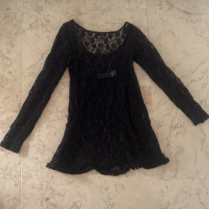 svart spetsklänning - svart spetsklänning med en söt rosett!! hur fin som helst. känns lite ledsamt att behöva göra sig av med den därav priset (går att pruta). romantic goth vibe men kan säkert även passa stockholmstjejer!