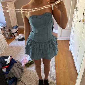 Jeansklänning - Jättesöt jeansklänning med volanger i storlek 38. Den är aldrig använd i helt nytt skick! Tror att den är köpt på asos men det står inte på💗