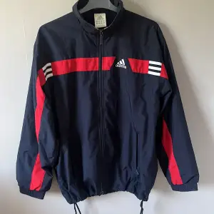 vindjacka från adidas, köpt på secondhand men väldigt bra skick. man kan dra åt vid midjan men annars väldigt baggy. står ingen stolek men passar både S/M/L  