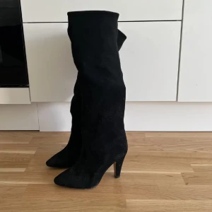 Snygga höga stövlar i mocka imitation perfekt för utgång - Storlek 39 från H&M, ser som nya ut men har används 3 gånger. Så lite skitiga under sulan. Minns inte helt vad jag köpte de för men närmare 800kr.  Super snygga med lagom hög klack, men kommer tyvärr inte till användning:( 💖   Skriv för fler bilder.