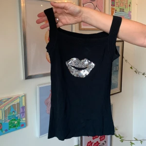 Svart linne med paljetter - Svarr linne med tjocka band och paljetter på framsidan. Lite längre topp och är väldigt bekväm. Väldigt stretchig så skulle nog passa XS till M!