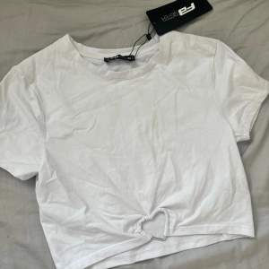 Cropped t shirt med en detalj på tröja , helt ny med prislapp