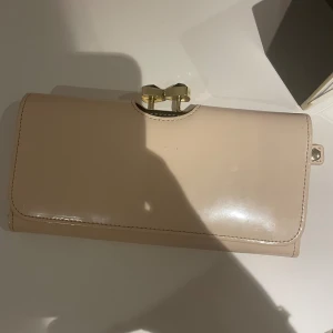 Ted baker plånbok - Använd en eller två gånger så den är som ny, ganska stor, finns plats för kort, mynt, sedlar, nypris ca 900?