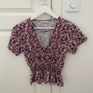 Blommig topp - Säljer denna somriga sommar toppen från Pull & Bear. Den är använd ett fåtal gånger. Säljer den pga att den inte är min stil längre.