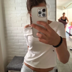 Vit offshoulder topp - En vit offshoulder topp med korta ärmar. Toppen är tight och har en enkel design som passar bra till vardags eller fest.