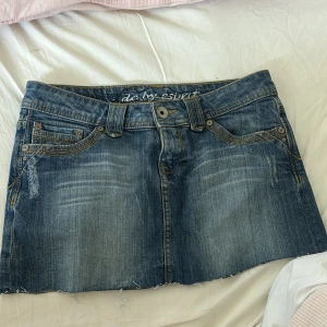 Lågmidjad jeanskjol - Midjemåttet rakt över: 38cm  Längd: 27cm Jätte snygg storlek 32, men sitter mer som 34. Använd gärna köp nu. 