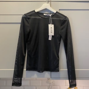 Helt ny svart mesh topp NAKD - Helt ny och oanvänd svart mesh topp med prislappar kvar från nakd. Skön och true to size. Nypris 229kr.