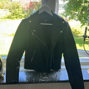 Skinnjacka - Säljer nu en skinnjacka från Bikbok då jag inte använder den och aldrig heller gjort det. Den är precis som ny och har bara hängt i min garderob. Bara de nedre fickorna är användbara. Nypris 899 och säljer för 699, öppen för prisförslag.🖤