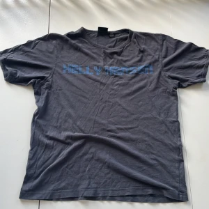 Helly Hansen tisha mörkblå - En mörkblå kortärmad t-shirt från Helly Hansen med blå text på framsidan. T-shirten är i storlek M och är tillverkad i Sri Lanka och i bra skick.