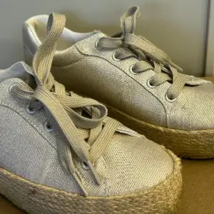 Silvriga sneakers med flätade detaljer i jute. Nästan helt oanvända.