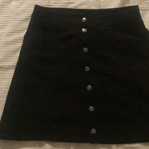 Kjol - Kjol som är svart med silvriga knappar 