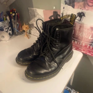 Svarta Doc Martens 1460 EU 40 - Doc martens i använt men bra skick. Har ett märke på insidan av vänstra skon men syns inte tydligt och går att laga om man vill. Sulorna är i bra skick och inte nedslitna vid hälarna. Fråga bara för fler bilder och Tvättar innan jag skickar. 