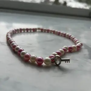 Jätte fint halsband vit och rosa med en liten nyckeln på använt en gång och i bra skick