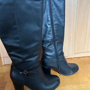 Svarta boots - Svarta boots i bra skick men en liten repa på ena klacken. Går till under knät