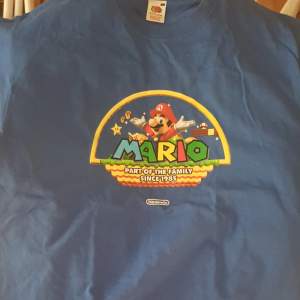 T-Shirt med Super Mario tryck på fronten och Wii och Nindendo DS på ärmarna