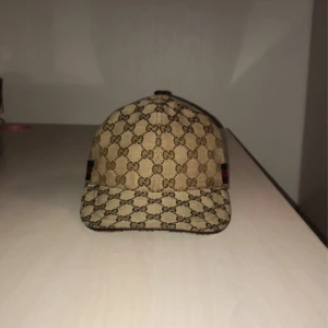 Gucci keps  - Denna Gucci keps är i jätte bra skick och är endast använd ett par gånger så är inprincip ny. Den är väldigt stilig och matchar till inprincip allt enligt mig och passar till alla väder. Den är också väldigt populär.