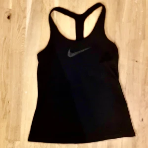 Nike Dri-Fit Träningslinne med tränings-bh inbyggt  - Svart träningslinne, något längre och mycket skön. Storlek S med inbyggd träningsbh. 