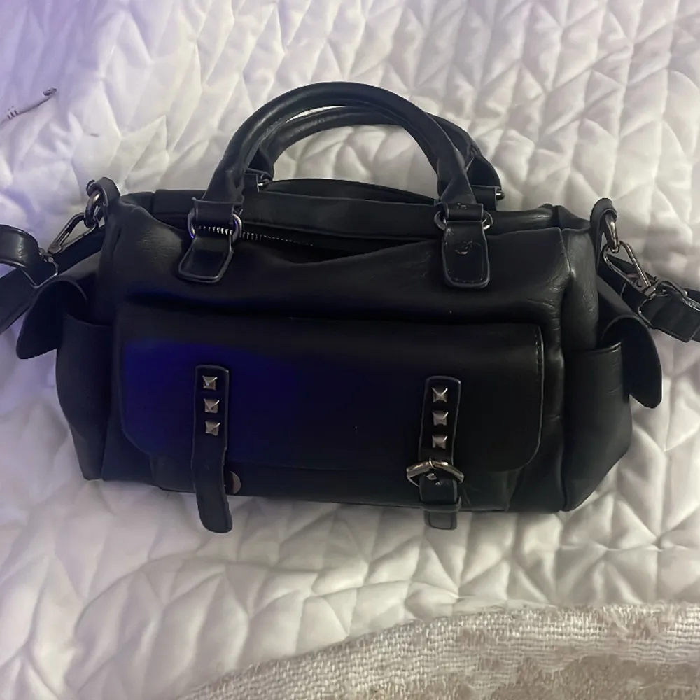En svart fin väskan har dock en skada i vänstra knappen i fram facket, den har annars bra skick och är jätte rymlig och har många fack💘. Väskor.