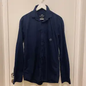 Jack & Jones skjorta i en fin mörkblå färg, i bra skick utan defekter! Stl L men är mer som en M då den är liten i storleken