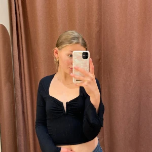 Svart långärmad topp - En långärmad topp med utsvängda armar och urringning i bysten! Ssåååå fiiin! Älskar den, först i kvarn!