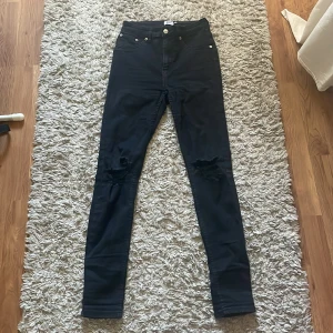 Svarta jeans me hål på knäna  - Svarta jeans som e tightfit me hål på knäna. Köpta på 157 för några år sedan och har inte riktigt kommit till användning  Har dom även i medium!!
