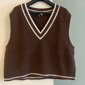 V-ringad stickad väst - Brun v-ringad stickad väst i storlek L. Köpt på H&M, aldrig använd. Mer som en storlek M, kort i modellen. 