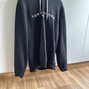 Tommy Hilfiger Hoodie - En Tommy Hilfiger hoodie som är i bra skick, använd några gånger men är fortfarande i ett skick som anses som bra.   Priset är ej hugget i sten! 🙂passar även L!