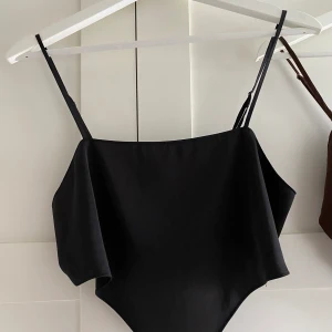 En svart topp som är triangelformad - En svart triangelformad festtopp i tunnt material. En jättefin topp till fester eller middagar. Toppen kommer från hm och är i storlek s. 