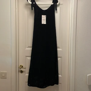 Svart stickad klänning med knutna axelband - Svart stickad klänning med knutna axelband Aldrig använd. Något liten i storlek jag har normalt S i kläder