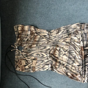 halterneck-topp - halterneck-topp med cool ringdetalj och knytande med silvriga pärlor på. väldigt coolt mönster och fin passform. 