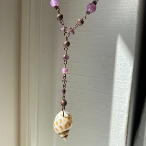 Halsband  - Halsband med lila pärlor och en snäcka, unikt och fint men används inte längre🌸