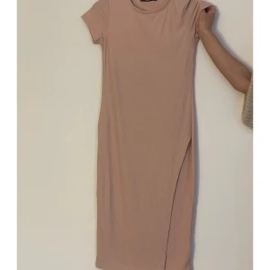 Midiklänning - Babyrosa midiklänning som använts ett antal gånger, men är i superbra skick. Klänningen har en innerslits på höger sida av benet. Klänningen fungerar utmärkt på dag men även på kvällen. 