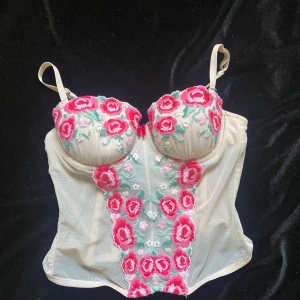 Pink korsett - Fin rosa korsett med broderade blomimslag. Bra skick, säljes då den är för liten för mig. Storlek XS/S