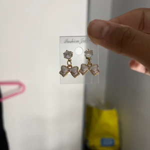 Rosett örhängen🎀🎀🎀 - Detta är ett par guldiga örhängen med vita rosetter på🎀🎀🎀 De är hemgjorda och är ej använda. Skriv privat för mer frågor💕💕(JAG STÅR FÖR FRAKT❤️❤️)