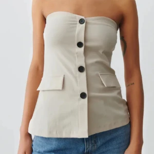 Gina beige kostym tubtopp/bandeau topp - Beige kostym-aktig tubtopp/bandeautopp med knappar från Gina Tricot, i nyskick