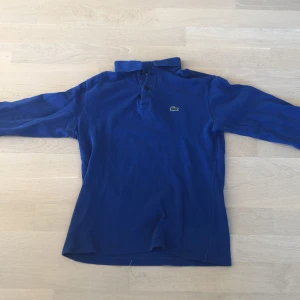 Lacoste pikétröja  - Hej! Jag säljer min Lacoste pikétröja i blå färg. Den är i bra skick och priset kan diskuteras.