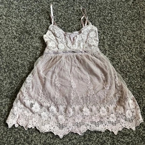 Grå/ rosa linne - Toppen är mer grå rosa i verkligheten än vad de ser ut på bild, mjukt material på insidan men utanpå är de lace, topp delen av linnet täcker brösten och de andra hänger ner och täcker resten av magen